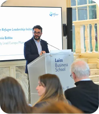 Antonio Bebba speaking from a Luiss Business School lectern, his slide on the screen behind him.