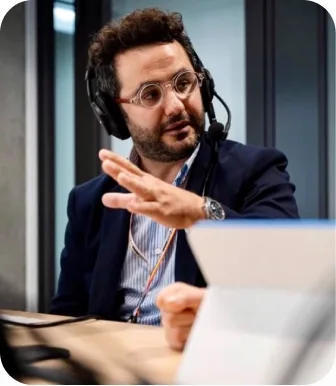 Antonio Bebba in a headset mid-gesture during a recorded interview.