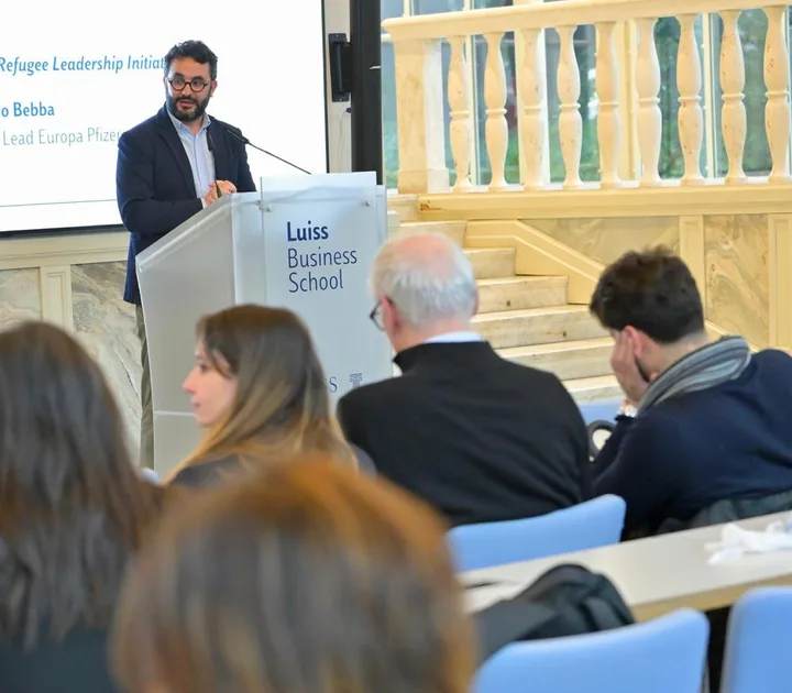 Antonio Bebba speaking from a Luiss Business School lectern in Rome.